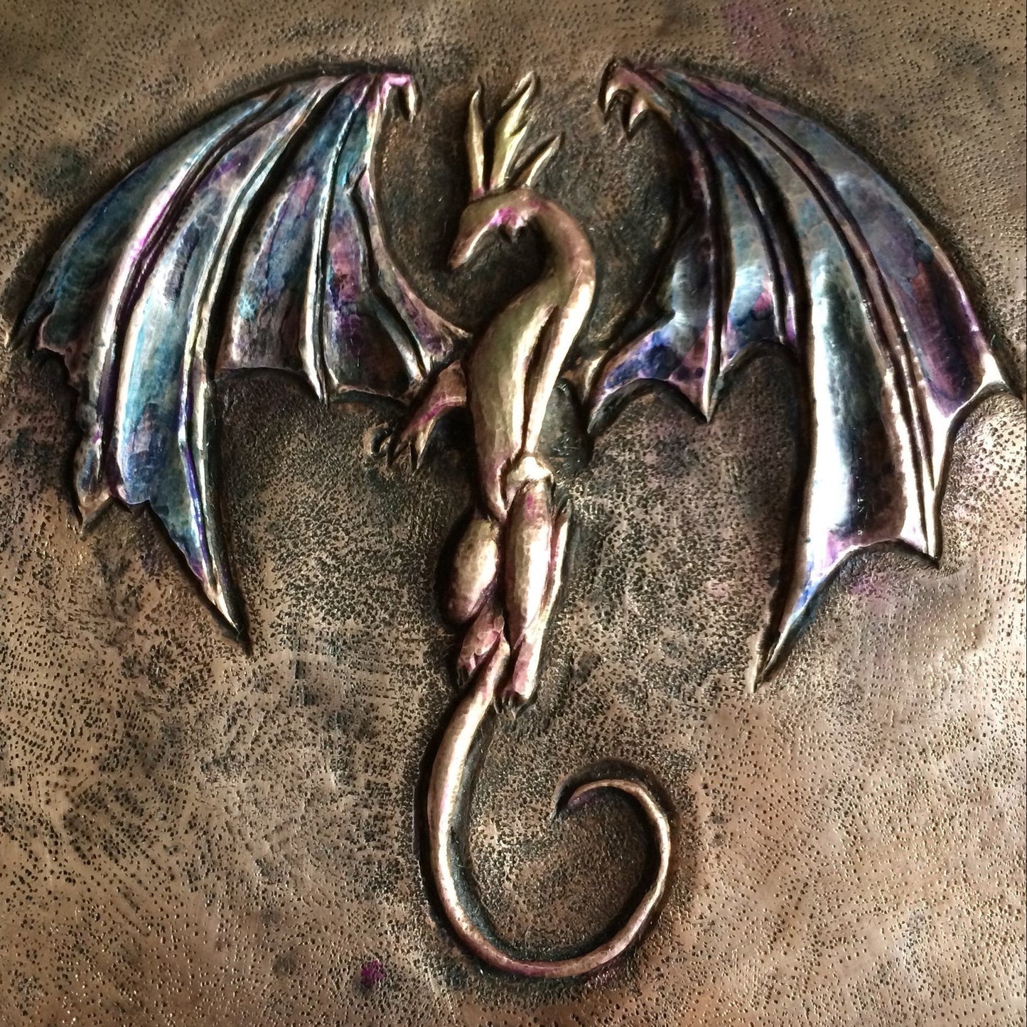Metallic dragon emblem on a textured bronze surface