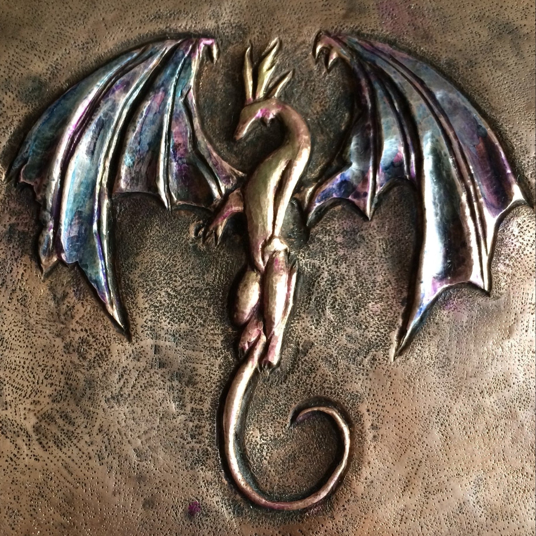 Metallic dragon emblem on a textured bronze surface