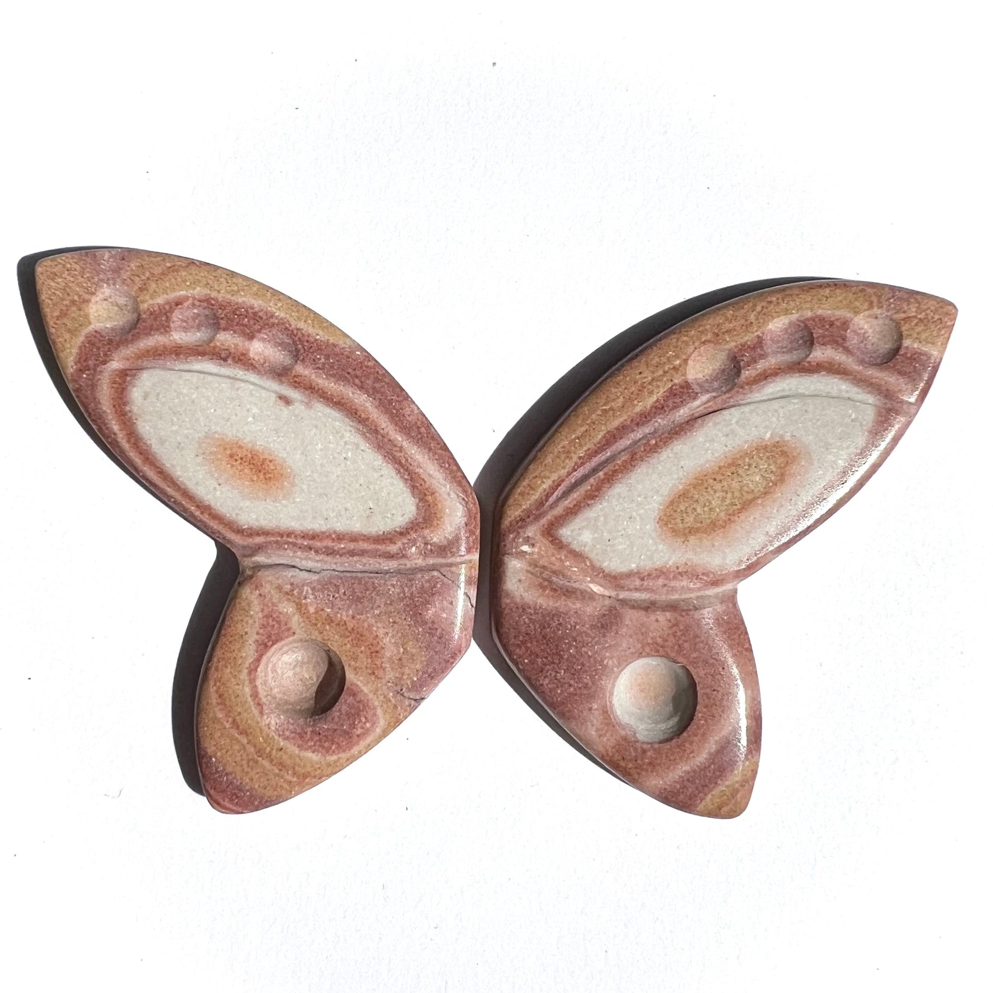 Butterfly-shaped stone piece with brown and beige patterns on a white background