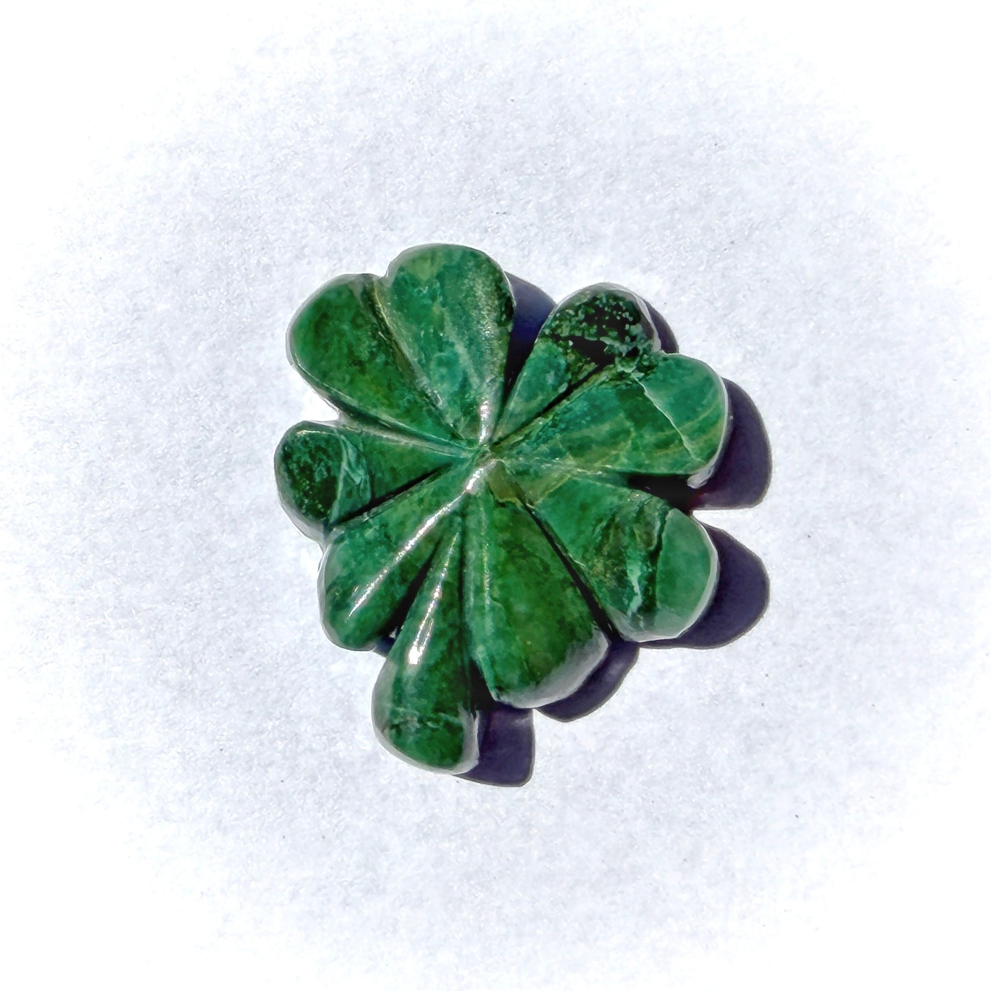 Green stone with a leaf-like pattern on a white background